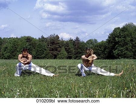 Stock Image - two gay men doing wellness exercises in park. Fotosearch