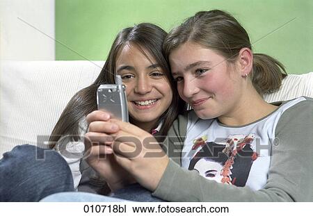 two girls looking at display of mobile phone View Large Photo Image Stock Image - two girls looking at display of mobile phone. Fotosearch