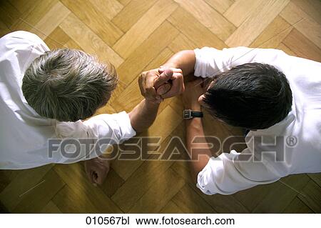 two men arm wrestling on the floor View Large Photo Image Stock Image - two men arm wrestling on the floor . Fotosearch