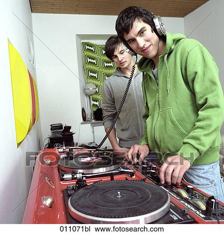 Two teenage boys standing at record player View Large Photo Image Stock Image - Two teenage boys standing at record player. Fotosearch