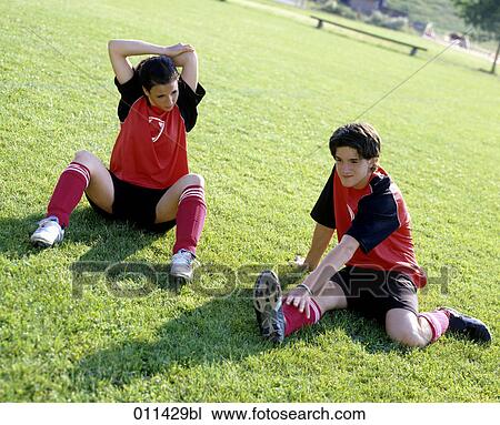 Stock Image - two teenagers warming up before football game. Fotosearch