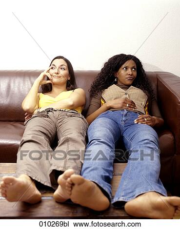 two women (25-30 years) on sofa not knowing what to do View Large Photo Image Stock Image - two women (25-30 years) on sofa not knowing what to do. Fotosearch