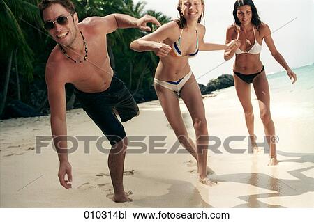 two women and one man enjoying beach life View Large Photo Image Stock Image - two women and one man enjoying beach life. Fotosearch