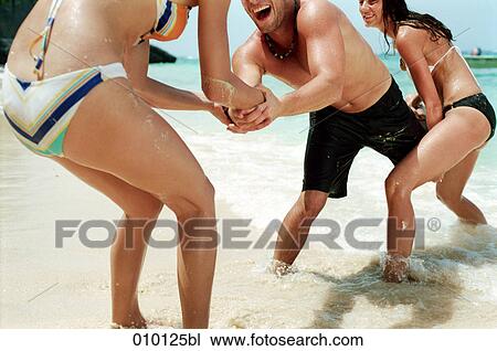 two women and one man playing on the beach View Large Photo Image Stock Image - two women and one man playing on the beach. Fotosearch