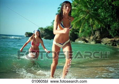 two young women coming out of the water on tropical beach View Large Photo Image Stock Image - two young women coming out of the water on tropical beach. Fotosearch