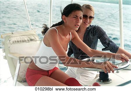 two young women steering a motor yacht View Large Photo Image Stock Image - two young women steering a motor yacht. Fotosearch