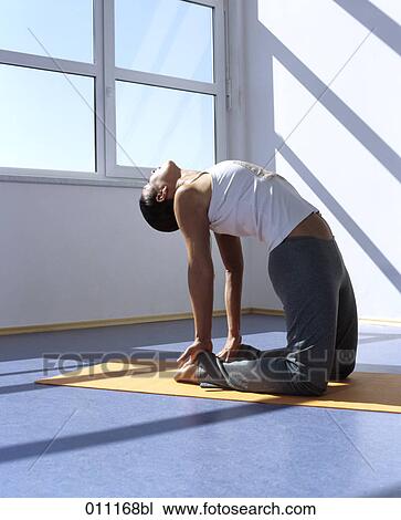 Stock Image - Woman demonstrating the wheel pose during yoga training. Fotosearch