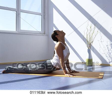 Woman doing yoga, performing the cobra pose View Large Photo Image Stock Image - Woman doing yoga, performing the cobra pose. Fotosearch