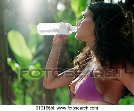 woman in bikini drinking water from plastic bottle View Large Photo Image Stock Image - woman in bikini drinking water from plastic bottle. Fotosearch