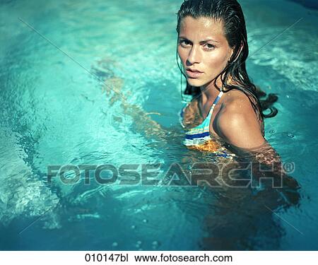 Stock Image - woman in swimming pool looking into camera. Fotosearch