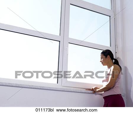 Stock Image - Woman looking out of window. Fotosearch