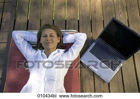 woman relaxing on her veranda, laptop beside her View Large Photo Image Stock Image - woman relaxing on her veranda, laptop beside her. Fotosearch