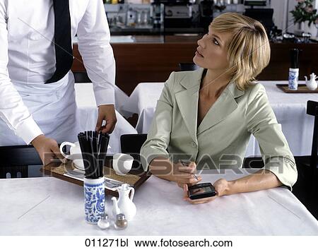 woman working with electronic organizer while being served in restaurant View Large Photo Image Stock Image - woman working with electronic organizer while being served in restaurant. Fotosearch