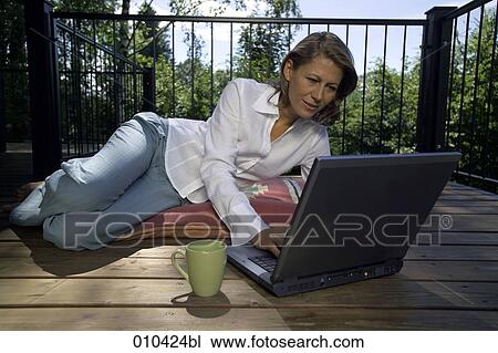 woman working with laptop on her veranda at home View Large Photo Image Stock Image - woman working with laptop on her veranda at home. Fotosearch