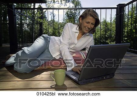 woman working with laptop on her veranda at home View Large Photo Image Stock Image - woman working with laptop on her veranda at home. Fotosearch