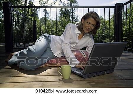 woman working with laptop on her veranda at home View Large Photo Image Stock Image - woman working with laptop on her veranda at home. Fotosearch