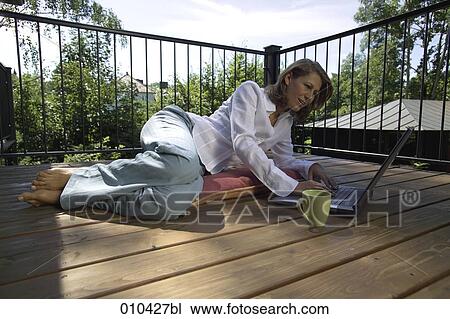 woman working with laptop on her veranda at home View Large Photo Image Stock Image - woman working with laptop on her veranda at home. Fotosearch