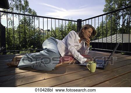 woman working with laptop on her veranda at home View Large Photo Image Stock Image - woman working with laptop on her veranda at home. Fotosearch
