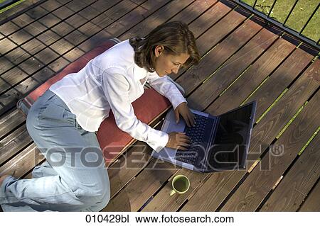 woman working with laptop on her veranda at home View Large Photo Image Stock Image - woman working with laptop on her veranda at home. Fotosearch