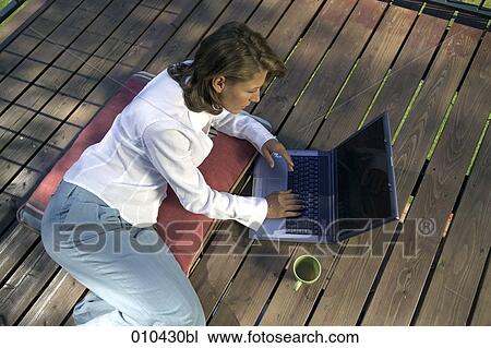 woman working with laptop on her veranda at home View Large Photo Image Stock Image - woman working with laptop on her veranda at home. Fotosearch