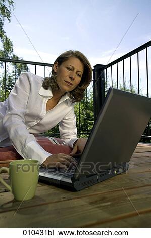 woman working with laptop on her veranda at home View Large Photo Image Stock Image - woman working with laptop on her veranda at home. Fotosearch