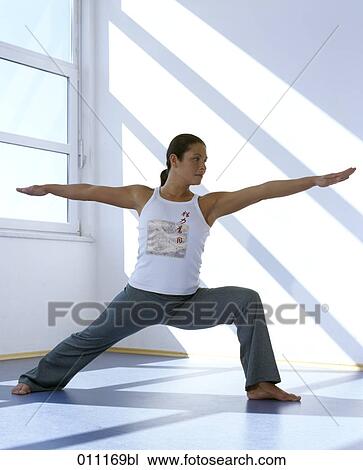 Yoga training, woman doing the warrior pose View Large Photo Image Stock Image - Yoga training, woman doing the warrior pose. Fotosearch