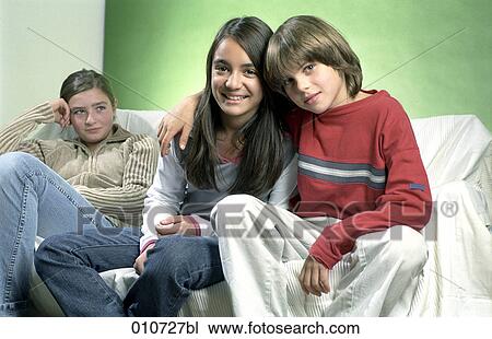 Stock Image - young boy embracing girl while other in the background is looking jealous. Fotosearch