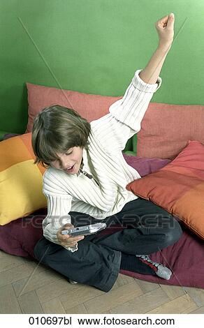 young boy playing with gameboy celebrating victory View Large Photo Image Stock Image - young boy playing with gameboy celebrating victory. Fotosearch