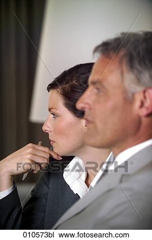 Stock Image - young businesswoman and mature colleague following a meeting. Fotosearch
