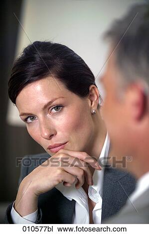 young businesswoman looking at mature colleague during meeting View Large Photo Image Stock Image - young businesswoman looking at mature colleague during meeting. Fotosearch