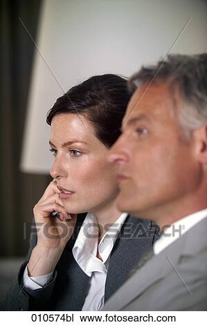 Stock Image - young businesswoman using a mobile phone during meeting. Fotosearch