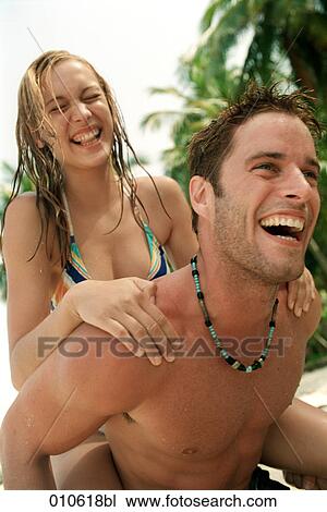 young couple enjoying a piggyback ride on a tropical beach View Large Photo Image Stock Image - young couple enjoying a piggyback ride on a tropical beach. Fotosearch