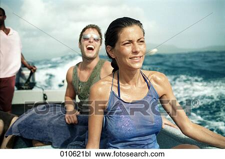 Stock Image - young couple enjoying a ride in a small motorboat. Fotosearch