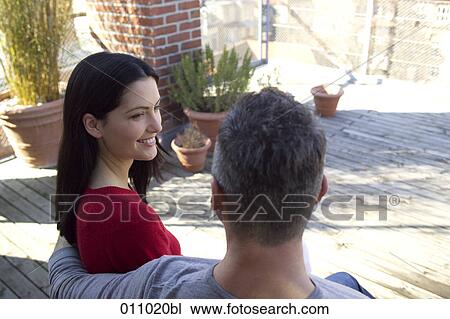 Young couple sitting on terrace View Large Photo Image Stock Image - Young couple sitting on terrace. Fotosearch
