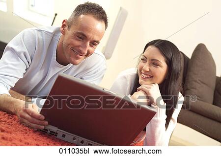 Stock Image - Young couple working with laptop computer. Fotosearch