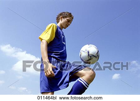 young football player bouncing the ball on his knee View Large Photo Image Stock Image - young football player bouncing the ball on his knee. Fotosearch