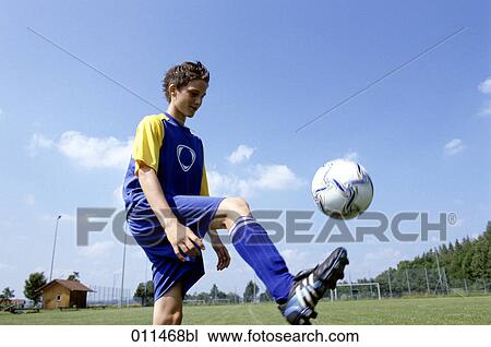 Stock Image - young footballer bouncing the ball. Fotosearch