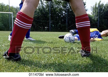 young footballer trying to keep the ball, seen through legs of his opponent View Large Photo Image Stock Image - young footballer trying to keep the ball, seen through legs of his opponent. Fotosearch