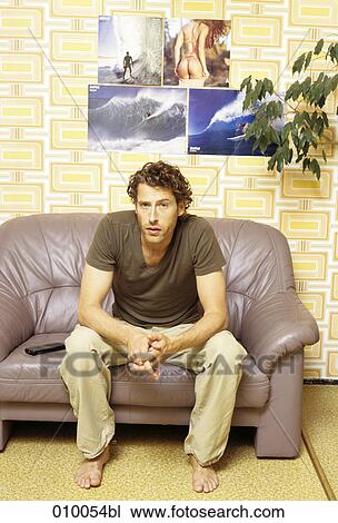 young male caucasian on grey leather sofa looking at camera View Large Photo Image Stock Image - young male caucasian on grey leather sofa looking at camera. Fotosearch