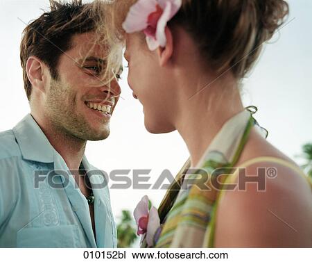 Stock Image - young man and woman smiling at each other. Fotosearch