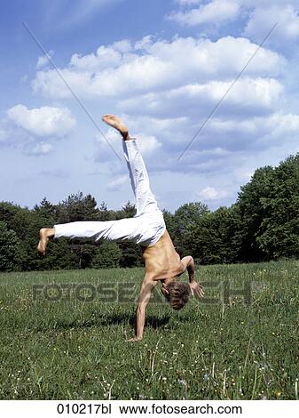 Stock Image - young man doing wellness training in the park. Fotosearch