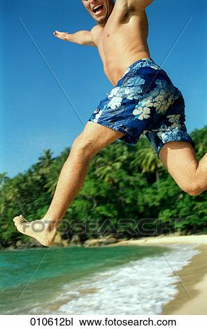 young man in blue trunks doing a high jump on the beach View Large Photo Image Stock Image - young man in blue trunks doing a high jump on the beach. Fotosearch
