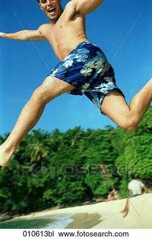 young man in blue trunks doing a high jump on the beach View Large Photo Image Stock Image - young man in blue trunks doing a high jump on the beach. Fotosearch