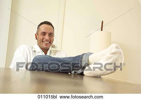 Young man laying his feet on the table View Large Photo Image Stock Image - Young man laying his feet on the table. Fotosearch