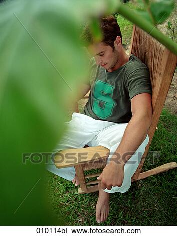 young man relaxing on rocking chair View Large Photo Image Stock Image - young man relaxing on rocking chair. Fotosearch