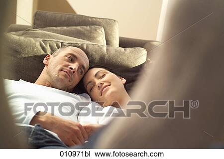 Stock Image - Young man watching his girlfriend while seh is sleeping. Fotosearch