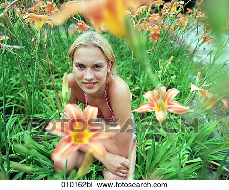 Stock Image - young teenage woman in a field of lilies. Fotosearch