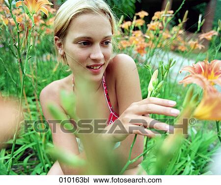 Stock Image - young teenage woman in a field of lilies. Fotosearch