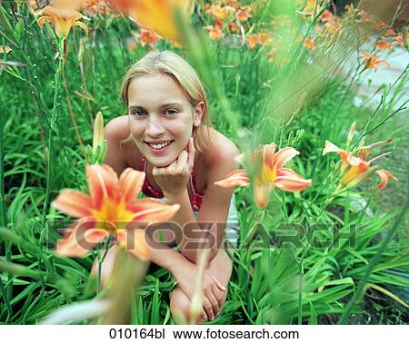 Stock Image - young teenage woman in a field of lilies. Fotosearch
