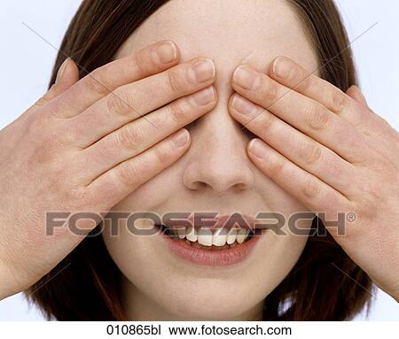 Stock Image - Young woman covering her eyes with the hands. Fotosearch